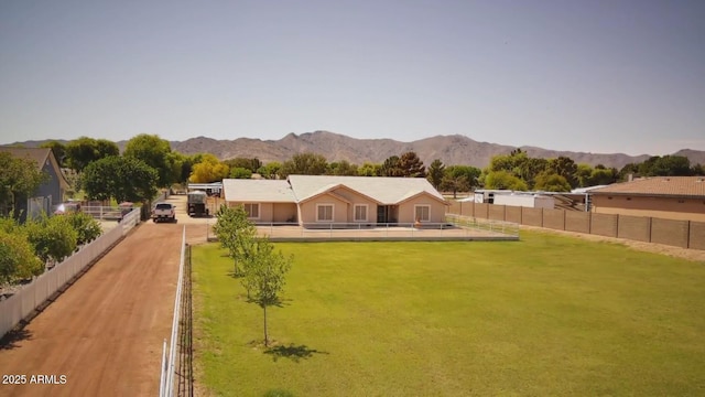 back of house featuring a mountain view, fence, and a yard