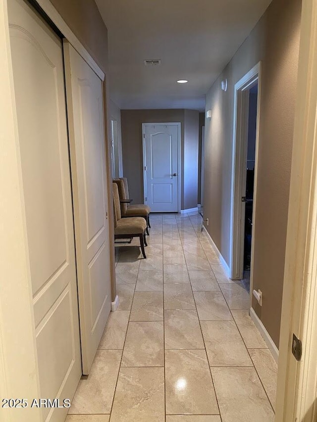 hall with baseboards and visible vents