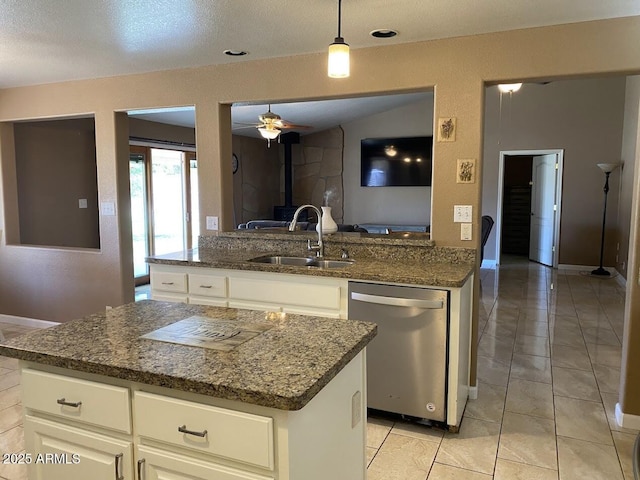 kitchen featuring dark stone countertops, a ceiling fan, dishwasher, and a sink