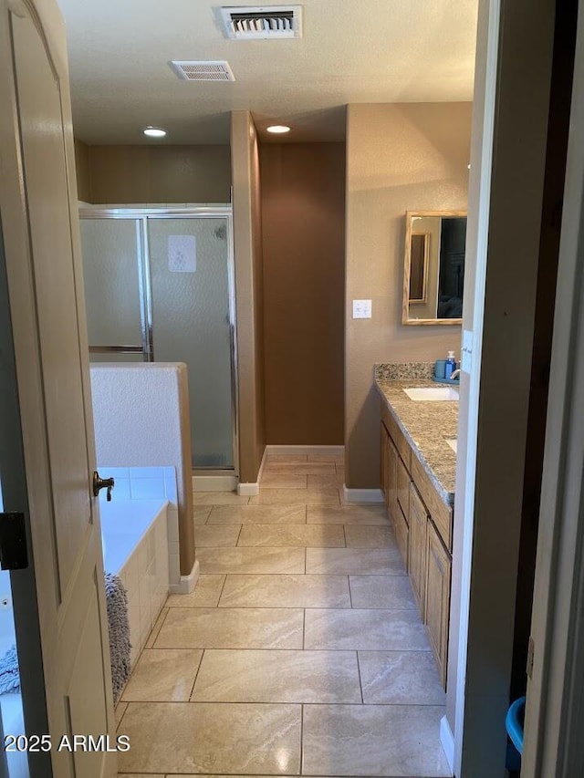 full bath featuring a stall shower, visible vents, a bath, and vanity
