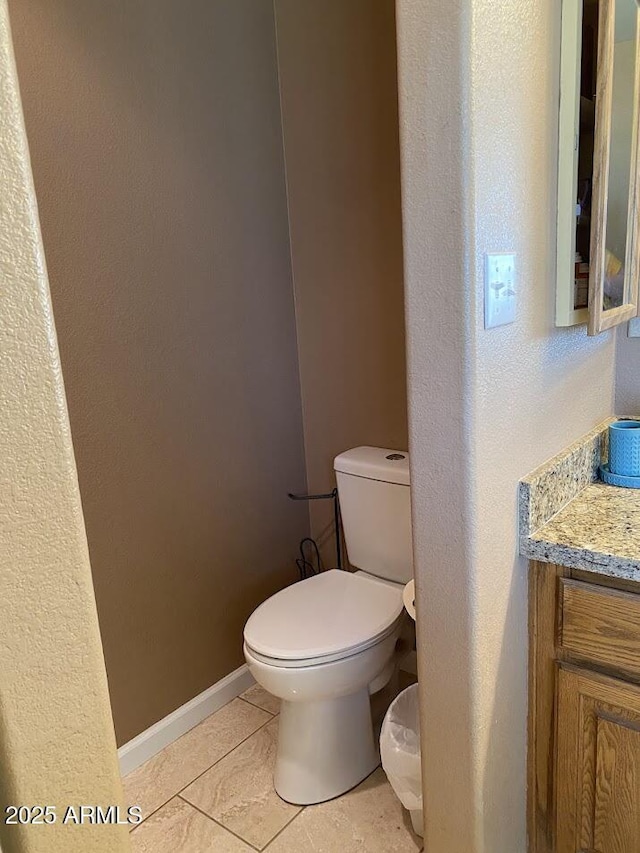 bathroom with baseboards, toilet, tile patterned flooring, and vanity
