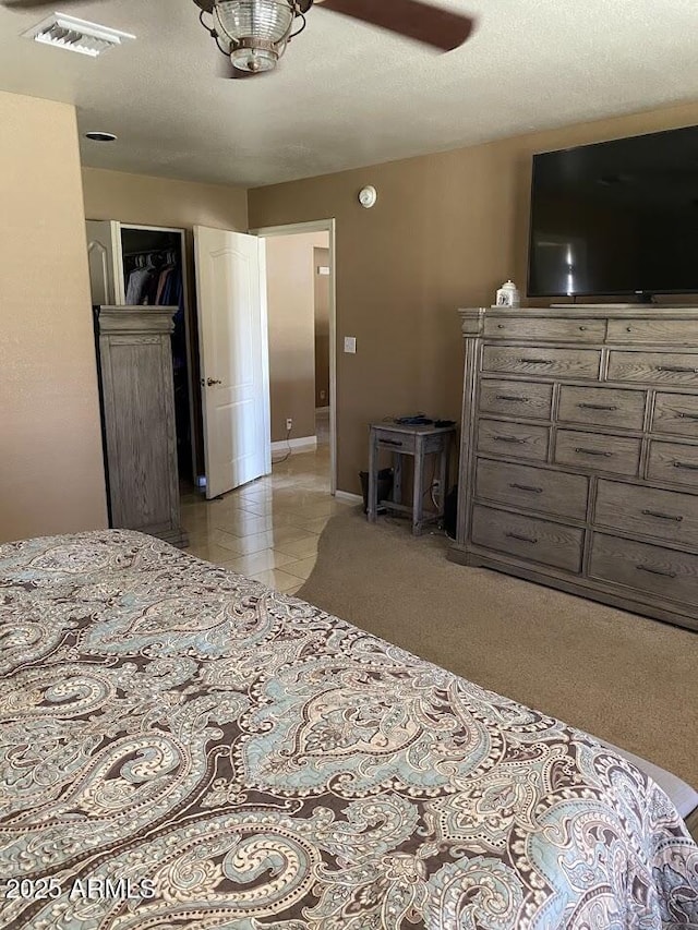 bedroom with baseboards, visible vents, and a ceiling fan