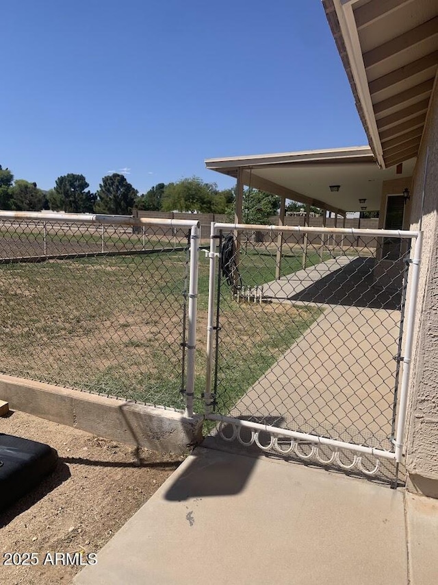 view of gate featuring a lawn and fence