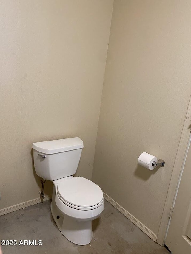 bathroom with toilet and baseboards