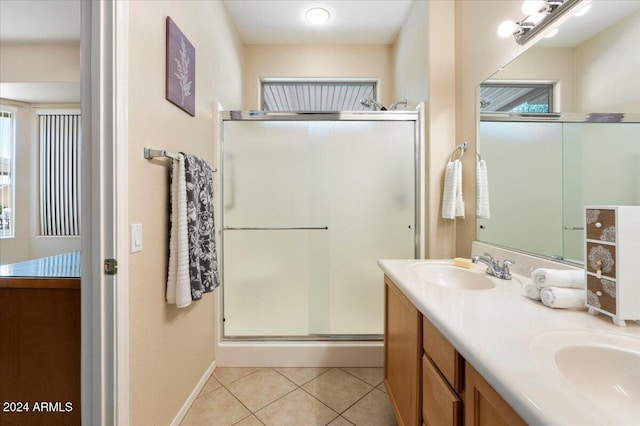 bathroom featuring a shower with door, tile patterned floors, and vanity