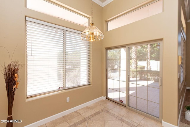 doorway to outside featuring an inviting chandelier, crown molding, and light tile patterned floors