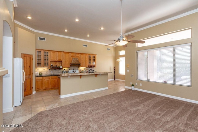 kitchen featuring light carpet, premium range hood, crown molding, and white refrigerator