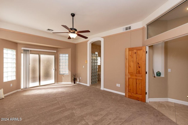 spare room featuring ceiling fan and light colored carpet