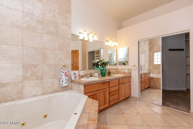 bathroom with vanity, tiled bath, and tile patterned floors