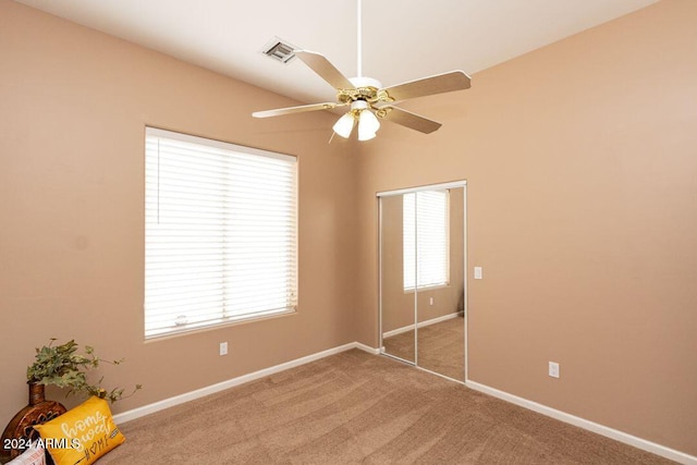 unfurnished bedroom with carpet flooring, a closet, and ceiling fan