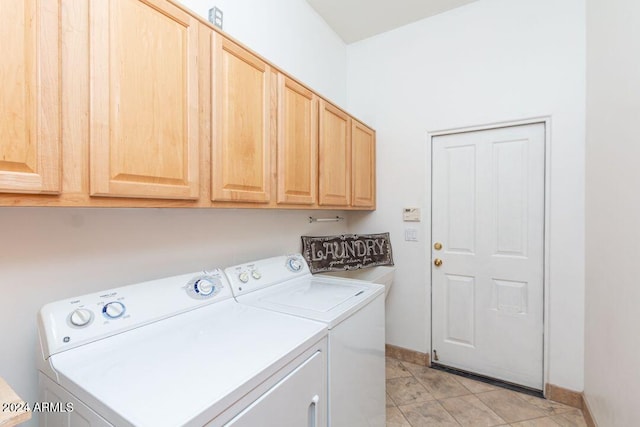 washroom with light tile patterned floors, cabinets, and washing machine and clothes dryer