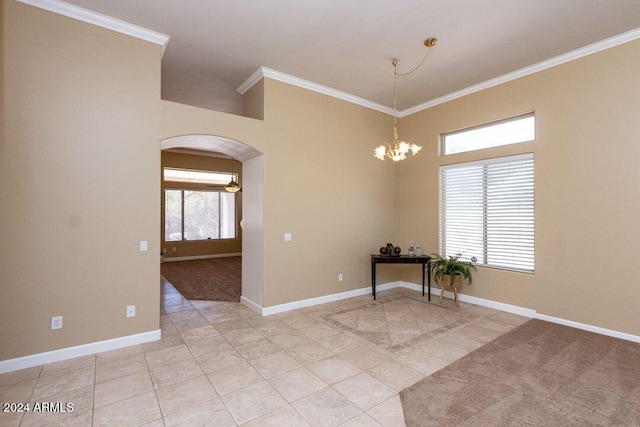 empty room with crown molding, light tile patterned flooring, and a chandelier