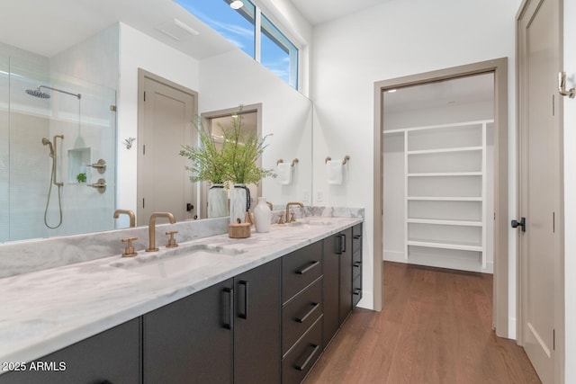 bathroom with walk in shower, vanity, and hardwood / wood-style flooring