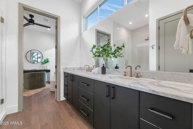 bathroom featuring hardwood / wood-style floors, vanity, ceiling fan, and a shower with shower door