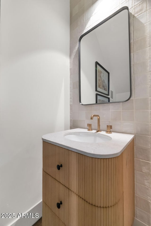 bathroom with vanity, backsplash, and tile walls