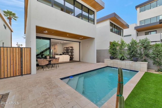 view of swimming pool featuring pool water feature and a patio