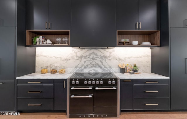 kitchen with decorative backsplash, light stone counters, and stainless steel range with electric cooktop