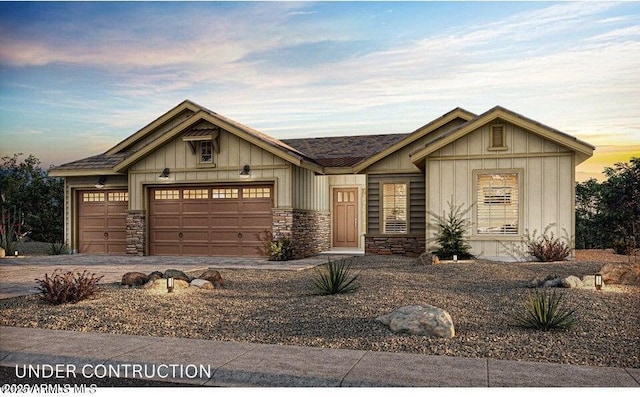 view of front of house with driveway, board and batten siding, a garage, and stone siding