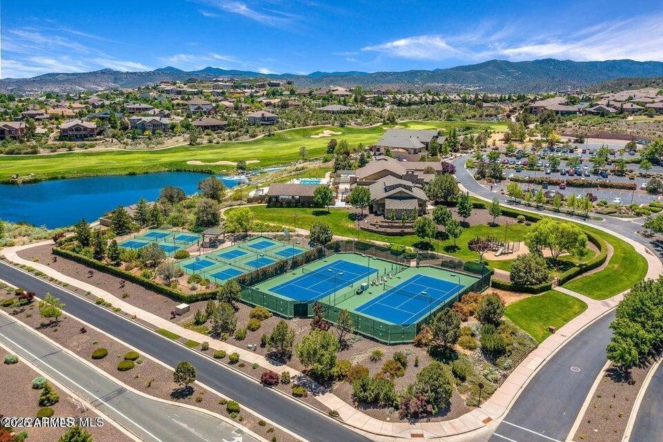 aerial view featuring golf course view, a water and mountain view, and a residential view