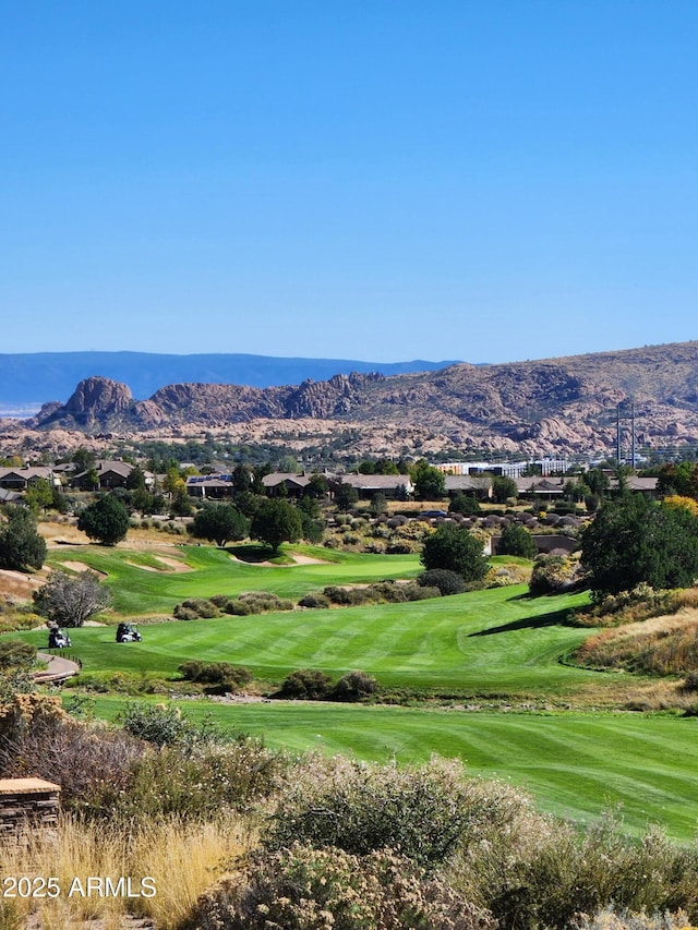 view of property's community with a yard, a mountain view, and view of golf course