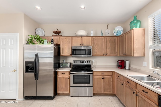 kitchen with sink, light tile patterned flooring, and appliances with stainless steel finishes