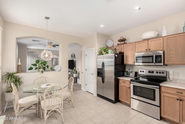 kitchen featuring decorative light fixtures, stainless steel appliances, ceiling fan, and light tile patterned flooring