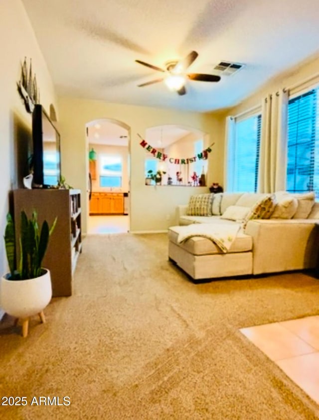 living room with carpet, a wealth of natural light, and ceiling fan