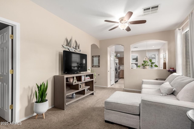 carpeted living room featuring a wealth of natural light and ceiling fan