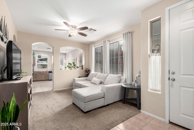 tiled bedroom featuring ensuite bathroom, ceiling fan, and sink