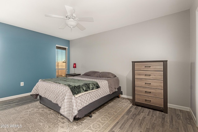 bedroom featuring dark wood-style flooring, a ceiling fan, and baseboards