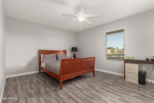 bedroom with ceiling fan, baseboards, and wood finished floors