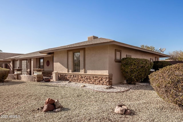 view of property exterior with stone siding and stucco siding
