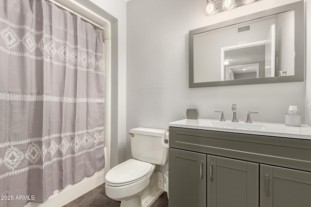 bathroom featuring toilet, curtained shower, vanity, and visible vents