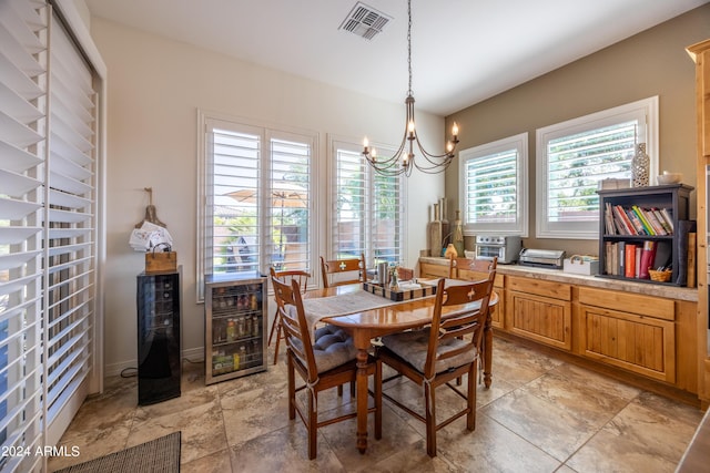 dining area featuring beverage cooler and a chandelier