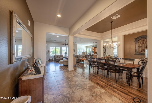 dining space with ceiling fan with notable chandelier and hardwood / wood-style floors