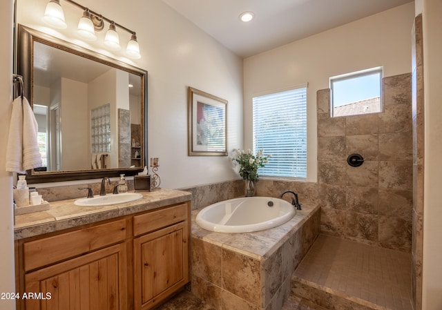 bathroom featuring vanity and independent shower and bath