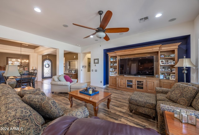 living room featuring hardwood / wood-style flooring and ceiling fan with notable chandelier