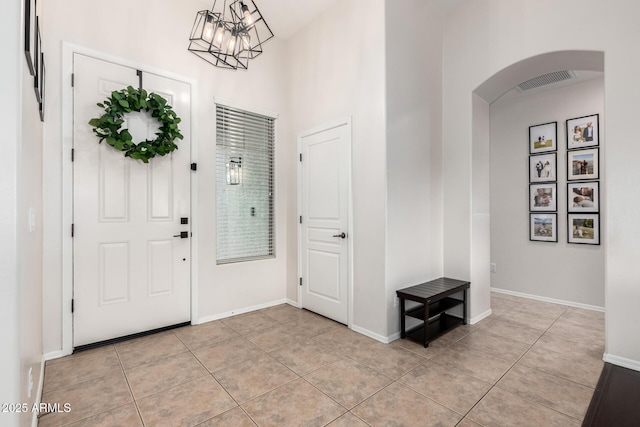 tiled foyer with an inviting chandelier