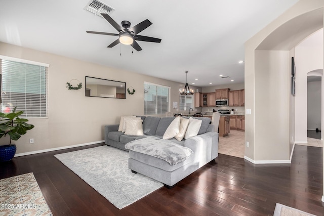 living room featuring sink, dark hardwood / wood-style flooring, and ceiling fan with notable chandelier