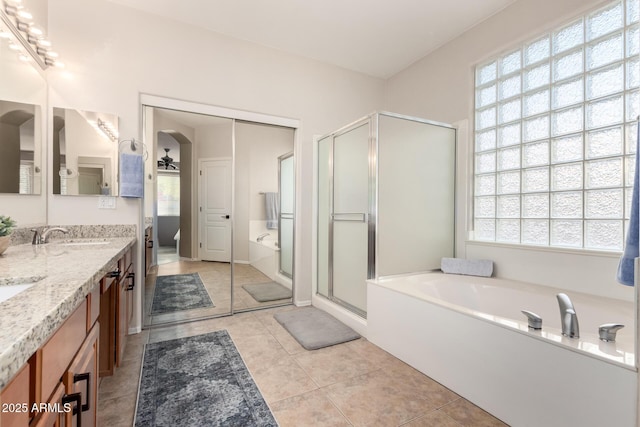 bathroom with vanity, a wealth of natural light, tile patterned floors, and plus walk in shower