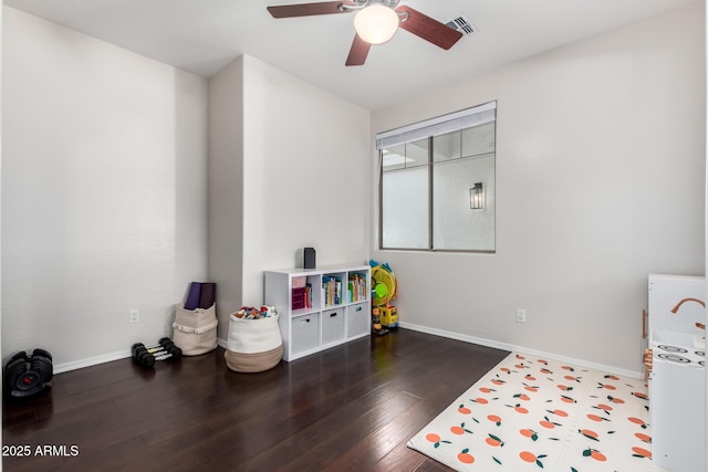 game room with dark wood-type flooring and ceiling fan