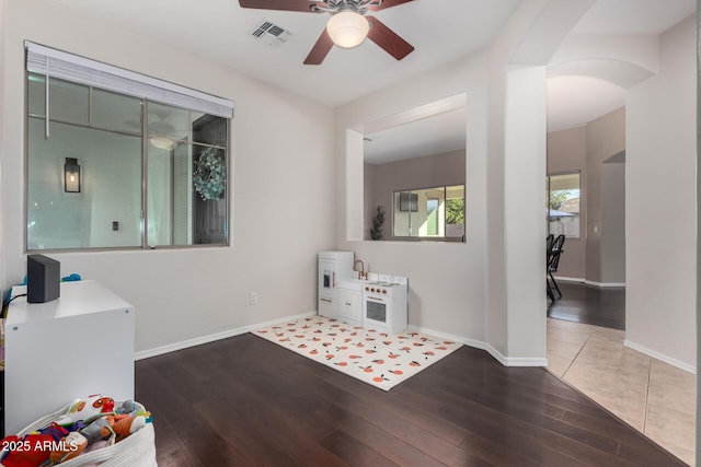 interior space with wood-type flooring and ceiling fan