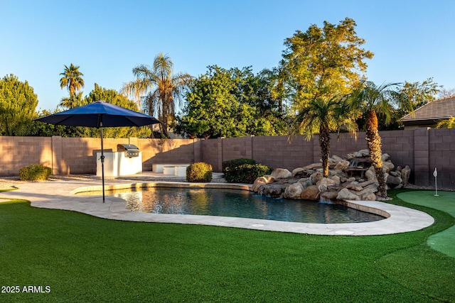 view of swimming pool with exterior kitchen, a yard, and a patio area