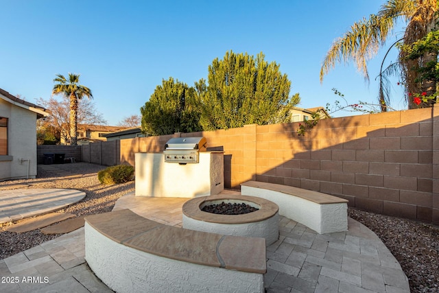 view of patio with area for grilling and a fire pit