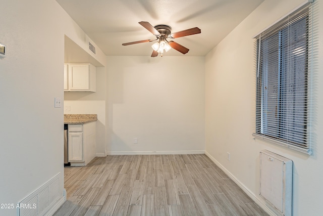 unfurnished dining area featuring light hardwood / wood-style flooring and ceiling fan