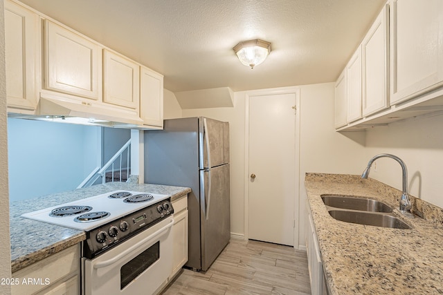 kitchen featuring sink, light stone countertops, light hardwood / wood-style floors, and white range with electric stovetop