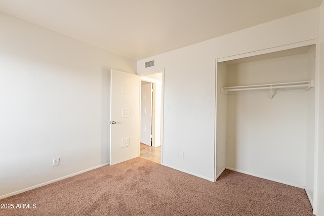 unfurnished bedroom with carpet floors and a closet