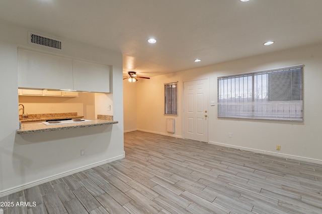 interior space with sink, ceiling fan, and light hardwood / wood-style floors