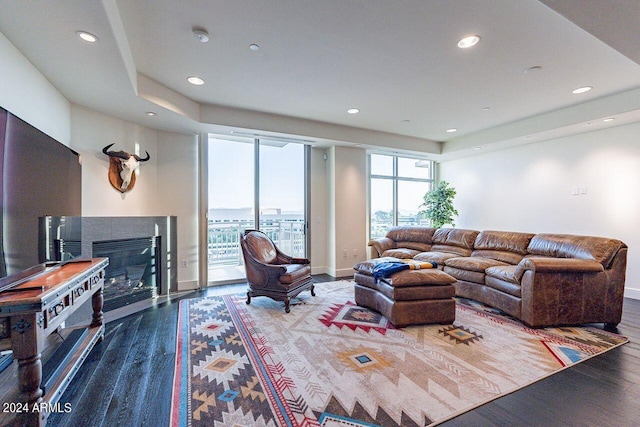 living room with wood-type flooring and a tile fireplace