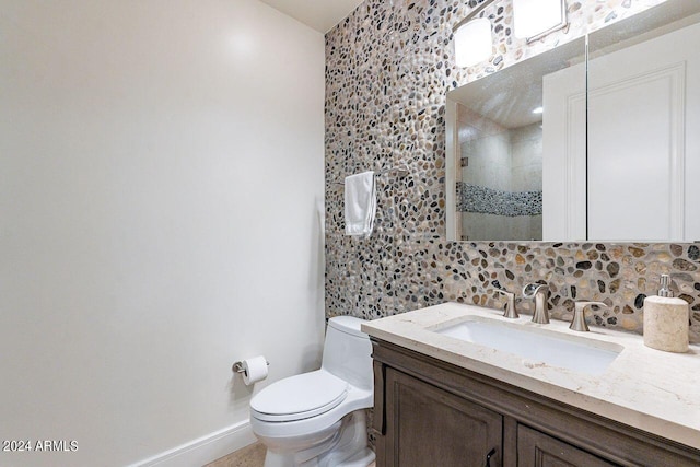 bathroom with vanity, walk in shower, toilet, and tasteful backsplash